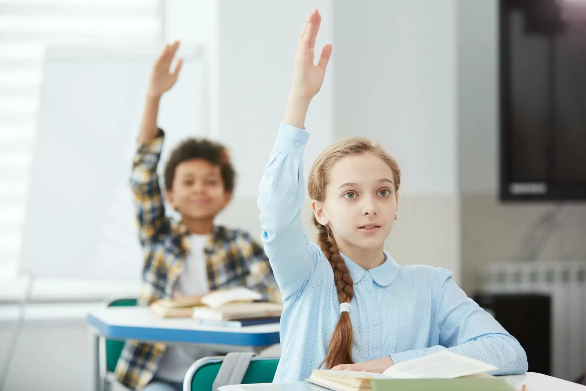 children-raising-hands-in-school